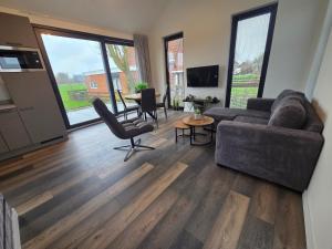 een woonkamer met een bank en een tafel bij Chalet aan het water in Sprong