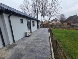 een loopbrug naast een huis met een tuin bij Chalet aan het water in Sprong