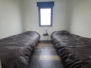 een bed in een kamer met een raam bij Chalet aan het water in Sprong