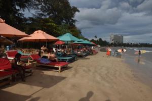 een strand met stoelen en parasols en mensen op het zand bij Diamond bay villa Weligama in Weligama +5 foto's