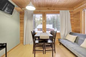 a dining room with a table and a couch at Pyhäkoti A - 30 Meters From the Slopes - Valkea Homes in Pyhätunturi +18 photos