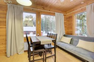 a dining room with a table and a couch at Pyhäkoti A - 30 Meters From the Slopes - Valkea Homes in Pyhätunturi
