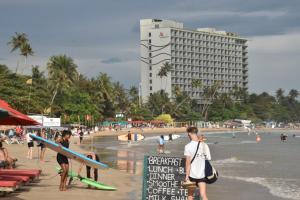 een groep mensen op een strand met een bord bij Diamond bay villa Weligama in Weligama