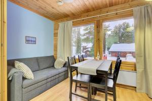a living room with a couch and a table at Pyhäkoti B - 30 Meters From the Slopes - Valkea Homes in Pyhätunturi
