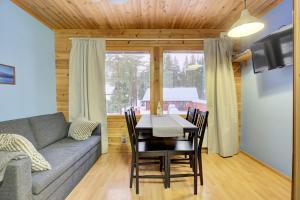 a living room with a couch and a table and chairs at Pyhäkoti B - 30 Meters From the Slopes in Pyhätunturi