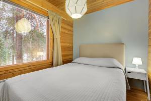 a bedroom with a bed and a large window at Pyhäkoti B - 30 Meters From the Slopes in Pyhätunturi