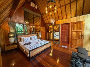 ein Schlafzimmer mit einem Bett in einem Zimmer mit Holzwänden in der Unterkunft Gili Treehouse in Gili Trawangan + 67 Fotos