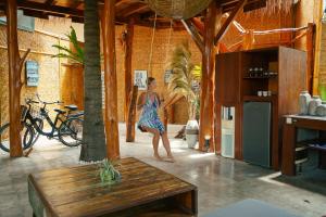 Eine Frau in einem blauen Kleid geht in einem Zimmer in der Unterkunft Gili Treehouse in Gili Trawangan