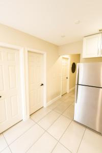 een keuken met een koelkast en witte kasten bij Paradiso Shores in Miami +7 foto's