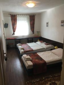 a room with three beds and a window at HARRYS City Motel in Komárno