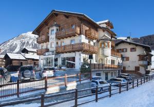 利维尼奥Hotel Crosal的一座大楼，前面停满了汽车