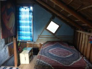 an attic room with a bed and a window at la remansa in Neptunia