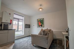ein Wohnzimmer mit einem Stuhl und eine Küche in der Unterkunft Bromyard Flat 3 - Relax & Unwind in Worcester