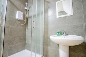 ein Badezimmer mit Waschbecken und Glasdusche in der Unterkunft Bromyard Flat 3 - Relax & Unwind in Worcester