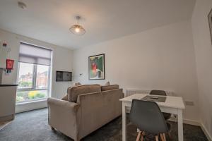 ein Wohnzimmer mit Sofa und Tisch in der Unterkunft Bromyard Flat 3 - Relax & Unwind in Worcester