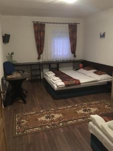 een slaapkamer met 2 bedden en een raam bij HARRYS City Motel in Komárno