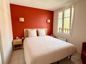 een slaapkamer met een wit bed en een rode muur bij Le Clos de Beaune in Levernois