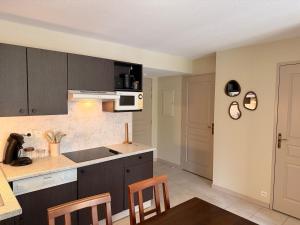 een keuken met bruine kasten en een tafel en stoelen bij Le Clos de Beaune in Levernois +10 foto's