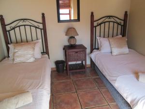 a room with two beds and a table with a lamp at Point Village Accommodation - Sean's House in Mossel Bay