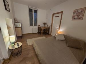 a bedroom with a bed and a table in it at Studio Bezine, Charmant petit studio centre ville in Angoulême