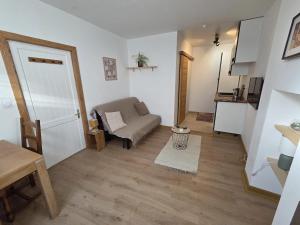 a living room with a couch and a table at Studio Bezine, Charmant petit studio centre ville in Angoulême +10 photos
