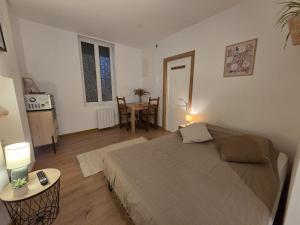 a bedroom with a large bed and a table at Studio Bezine, Charmant petit studio centre ville in Angoulême