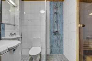a bathroom with a shower and a toilet and a sink at Pyhäkoti C - 30 Metres From the Slopes - Valkea Homes in Pyhätunturi