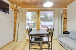 a dining room with a table and chairs and a couch at Pyhäkoti C - 30 Metres From the Slopes - Valkea Homes in Pyhätunturi