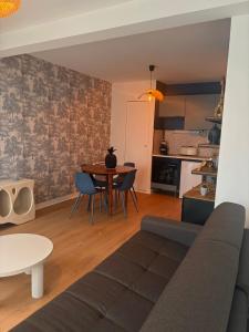 een woonkamer met een bank en een tafel bij Charmant appartement in Vitré