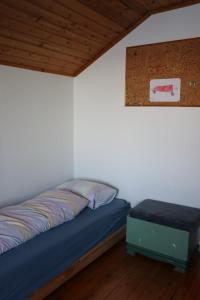 a bedroom with a bed and a table in it at Gammelbutikken Guesthouse in Pettvik
