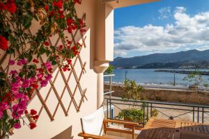 a balcony with flowers and a view of the water at Renas Guesthouse in Sitia