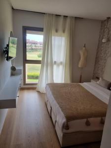 a bedroom with a large bed and a window at appartement prestige golf city in Marrakech