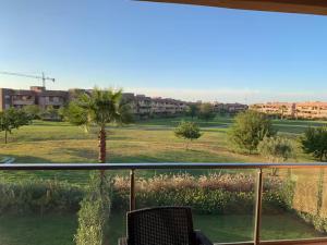 a view of a palm tree from a balcony at appartement prestige golf city in Marrakech