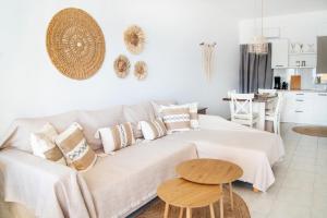 a white living room with a couch and a table at Renas Guesthouse in Sitia