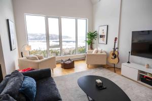 een woonkamer met een bank en een groot raam bij 403 - Luxury Condo - Incredible View & Pool in Baie-Saint-Paul