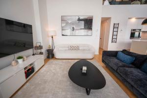 een woonkamer met een bank en een tafel bij 403 - Luxury Condo - Incredible View & Pool in Baie-Saint-Paul +54 foto's