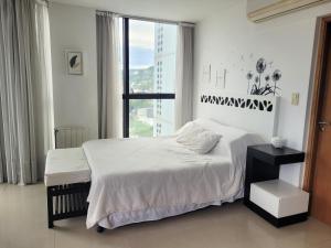 a bedroom with a white bed and a large window at Apartamento Ejecutivo Premium Riviera Tower in Villa Carlos Paz