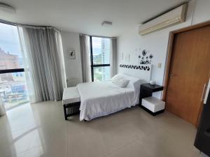 a bedroom with a white bed and a large window at Apartamento Ejecutivo Premium Riviera Tower in Villa Carlos Paz