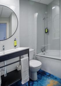 een badkamer met een toilet, een wastafel en een spiegel bij Hotel Sercotel Plana Onda in Onda +23 foto's