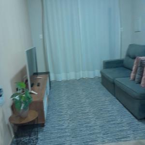 een woonkamer met een bank en een tv bij Casa Valen com 2 quartos in Rio de Janeiro +4 foto's