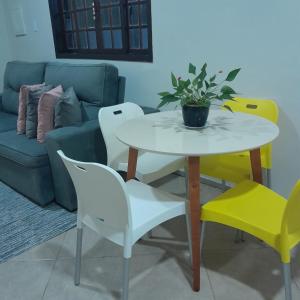 een tafel en stoelen in een woonkamer met een bank bij Casa Valen com 2 quartos in Rio de Janeiro
