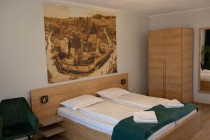 a bedroom with a bed with a painting on the wall at Pensiunea Draser in Şeica Mică