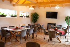 a room with tables and chairs and a flat screen tv at Pensiunea Draser in Şeica Mică