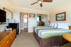 una camera d'albergo con un letto e una TV a schermo piatto di Ala Cozy Motel a Coulee City