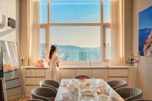 Una donna con un vestito bianco che guarda fuori da una finestra di House with Park View a Bucheon