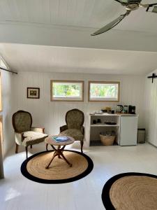 a living room with two chairs and a table at Piesang Valley Cottage Djungle in Plettenberg Bay