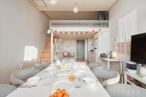 una sala da pranzo con tavolo e sedie bianchi di House with Park View a Bucheon