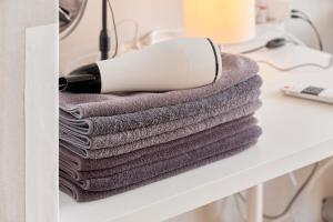 una pila di asciugamani su un tavolo con un asciugacapelli di House with Park View a Bucheon Altre 135 foto
