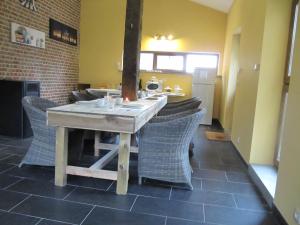 uma sala de jantar com uma mesa de madeira e cadeiras em B&B Bodegem em Dilbeek