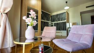 a living room with two chairs and a vase with flowers at Prestige holiday home Bed space in Dubai